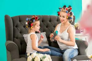 Portrait of cute little girl and her mom doing each other makeup photo