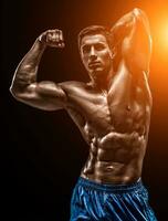 Muscular and fit young bodybuilder fitness male model posing ove photo