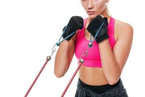Strong woman using a resistance band in her exercise routine. Young woman performs fitness exercises on white background. Close up photo