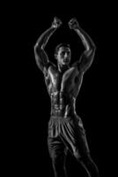 Muscular and fit young bodybuilder fitness male model posing ove photo
