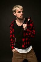 Image of attractive young bearded hipster man dressed in shirt in a cage isolated over black background. photo