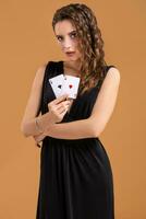 Beautiful brown-haired woman holding two aces as a sign for poker game, gambling and casino photo