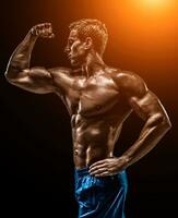 Muscular and fit young bodybuilder fitness male model posing ove photo