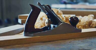 Elite professional carpenter's plane against the background of shavings and a sketch on paper of future furniture in a carpentry workshop video