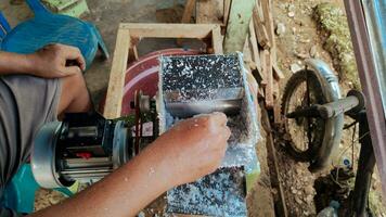 Human hands can be seen grating coconuts using a grater machine photo