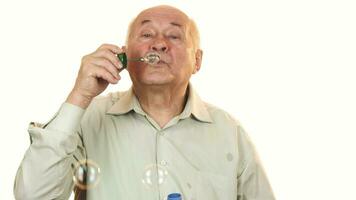 Senior cheerful man blowing bubbles isolated on white video