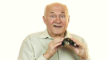 Old man using binoculars looking surprised to the camera video