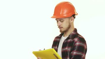 Young professional male contractor in hardhat making notes smiling video