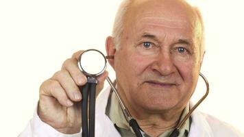 Senior male doctor holding up a stethoscope to the camera video