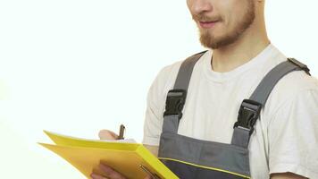 Cropped shot of a industry worker smiling making notes on clipboard video