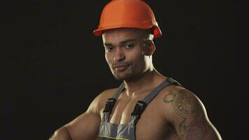 bonito muscular construcionista sorridente vestindo capacete de segurança video
