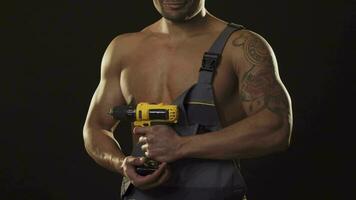 Cropped shot of a muscular shirtless repairman holding a drill video