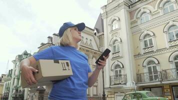 levering vrouw met pakket doos gebruik makend van slim telefoon online kaart video