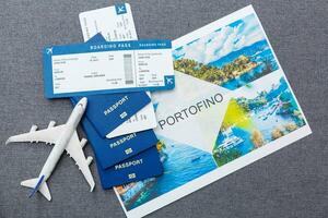 White blank model of passenger plane on passports with boarding pass on blue rustic wooden background photo
