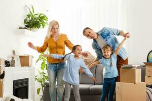 Happy family moving home with boxes around photo