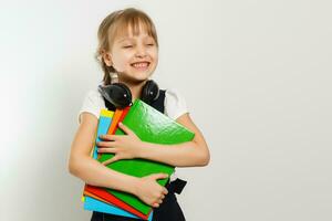 Blonde schoolgirl holds large book, shoot over white background photo