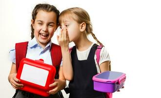 dos joven muchachas susurro y compartiendo un secreto durante clase en colegio foto