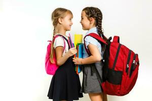 Two little schoolgirls. Education, fashion, friendship concept. photo