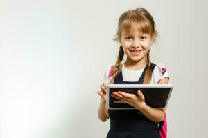 little blond school girl with backpack bag portrait isolated on white background photo