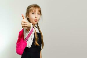 little blond school girl with backpack bag portrait isolated on white background photo