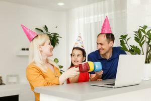 Happy family celebrating birthday via internet in quarantine time, self-isolation and family values, online birthday party photo