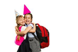 Pupils of primary school with lunch-boxes in hands. Girls with backpacks are eating fruit. Beginning of lessons. First day of fall. photo