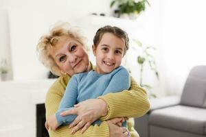 retrato de contento antiguo abuela y niño niña mirando a cámara, sonriente abuela con nieta haciendo vídeo llamar, niño y abuelita vloggers grabación vídeo Blog o vlog juntos foto