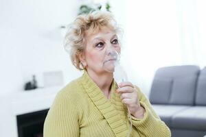 Sick elderly woman making inhalation photo