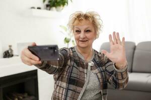 Concept of easy, fast usage of modern technology among all ages. Portrait of confident mature woman with wrinkles she is using her modern smartphone for sending a message isolated on gray background photo