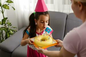 contento niña hermano celebrando cumpleaños vía Internet en cuarentena tiempo, autoaislamiento y familia valores, en línea cumpleaños fiesta. Felicidades animador vía computadora portátil, en línea. permanecer a hogar foto