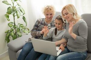 Grandmother and daughter teaching child use laptop application, playing game photo