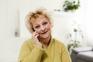 Concept of easy, fast usage of modern technology among all ages. Portrait of confident mature woman with wrinkles she is using her modern smartphone for sending a message isolated on gray background photo