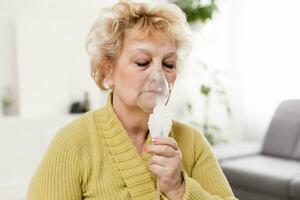 enfermo mayor mujer haciendo inhalación foto