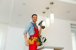 Electrician man worker installing ceiling lamp photo