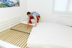 Young male contractor installing furniture at home photo