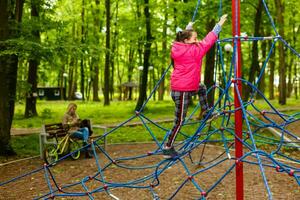 Adorable little girl enjoying her time in climbing adventure park photo