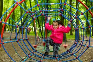 Adorable little girl enjoying her time in climbing adventure park photo