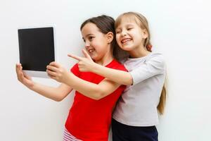 imagen de dos hermosa muchachas con tableta ordenador personal en blanco antecedentes foto