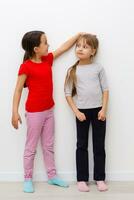 Two cute little girls in full growth, in the studio on a white background. The concept of a happy childhood, Beauty and fashion. Isolated. photo