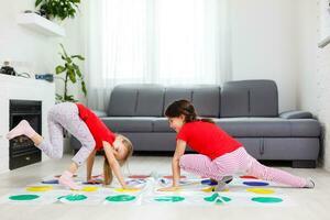 dos contento muchachas en para niños ropa con entusiasmo jugar en el piso. foto