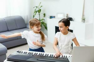 Home lesson on music for the girl on the piano. The idea of activities for the child at home during quarantine. Music concept photo