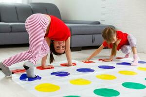 two little girls Having Fun Playing Game On Floor At Home. Siblings Friendship photo