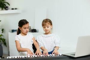 Home lesson on music for the girl on the piano. The idea of activities for the child at home during quarantine. Music concept photo