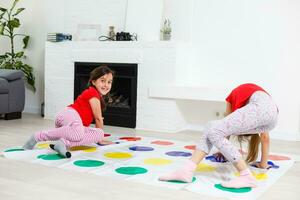 dos contento muchachas en para niños ropa con entusiasmo jugar en el piso. foto