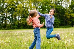 Two adorable girls dancing on the meadow photo