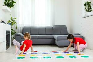 two little girls Having Fun Playing Game On Floor At Home. Siblings Friendship photo