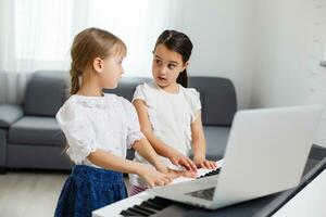 Home lesson on music for the girl on the piano. The idea of activities for the child at home during quarantine. Music concept photo