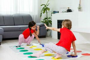 dos contento muchachas en para niños ropa con entusiasmo jugar en el piso. foto