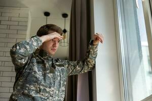 Nervous male military suffering depression, alone at home, PTSD concept. photo