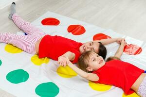 two little girls Having Fun Playing Game On Floor At Home. Siblings Friendship photo